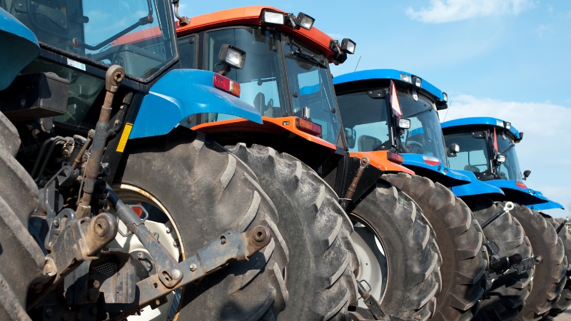 A row of utility tractors parked side by side