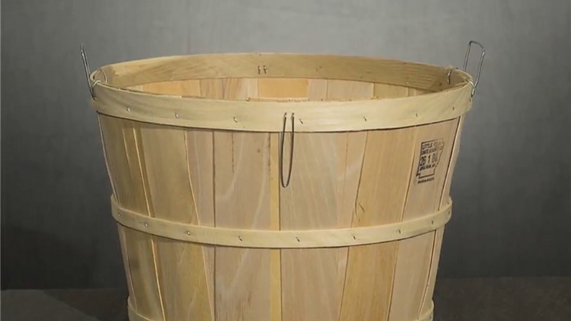 A wooden bushel basket used for measuring and carrying harvested crops