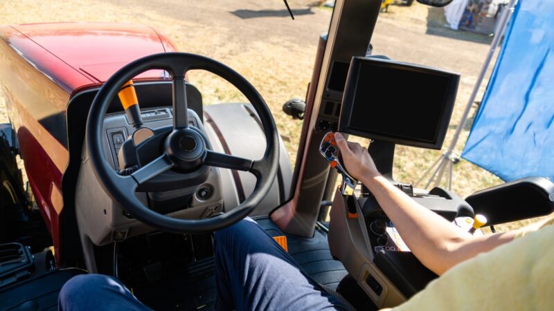 Operator uses a tractor control panel inside the cab